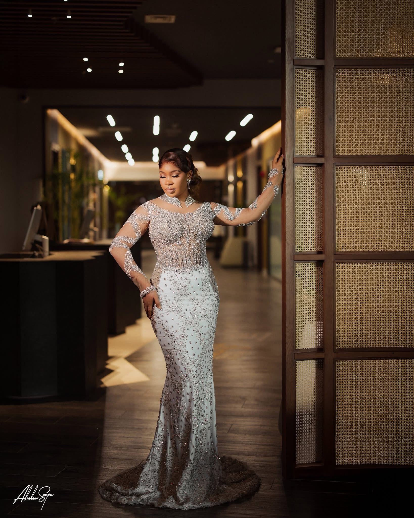 Silver crystal full-length gown in hotel corridor