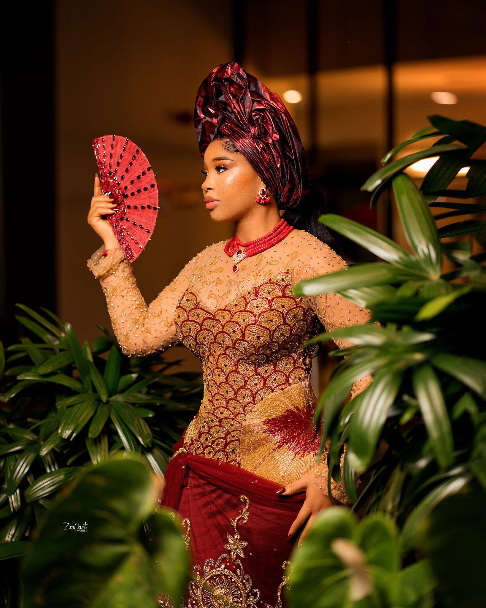 Red and gold traditional ceremony ensemble with hand fan
