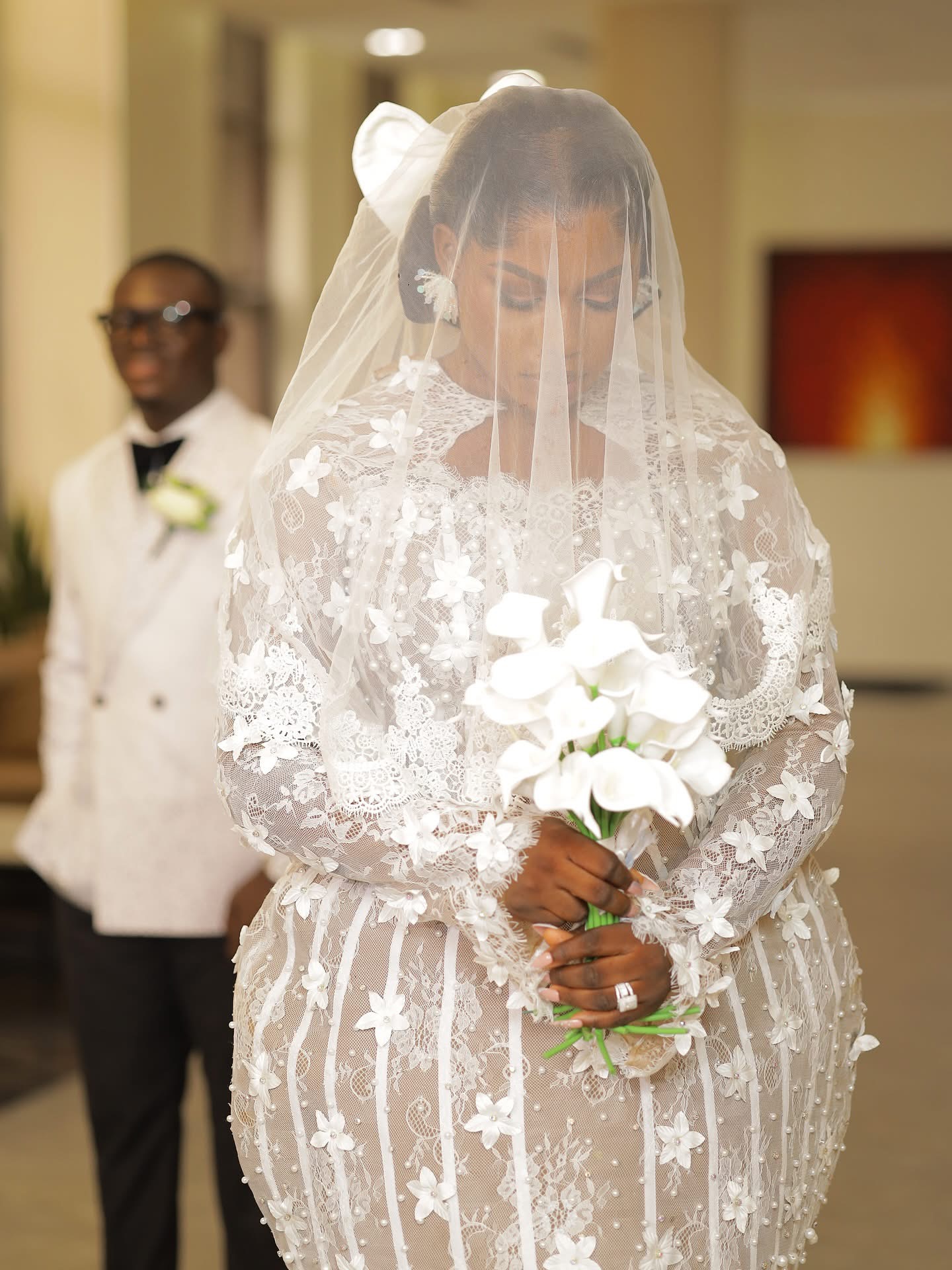 Bride with bouquet in lace gown and veil