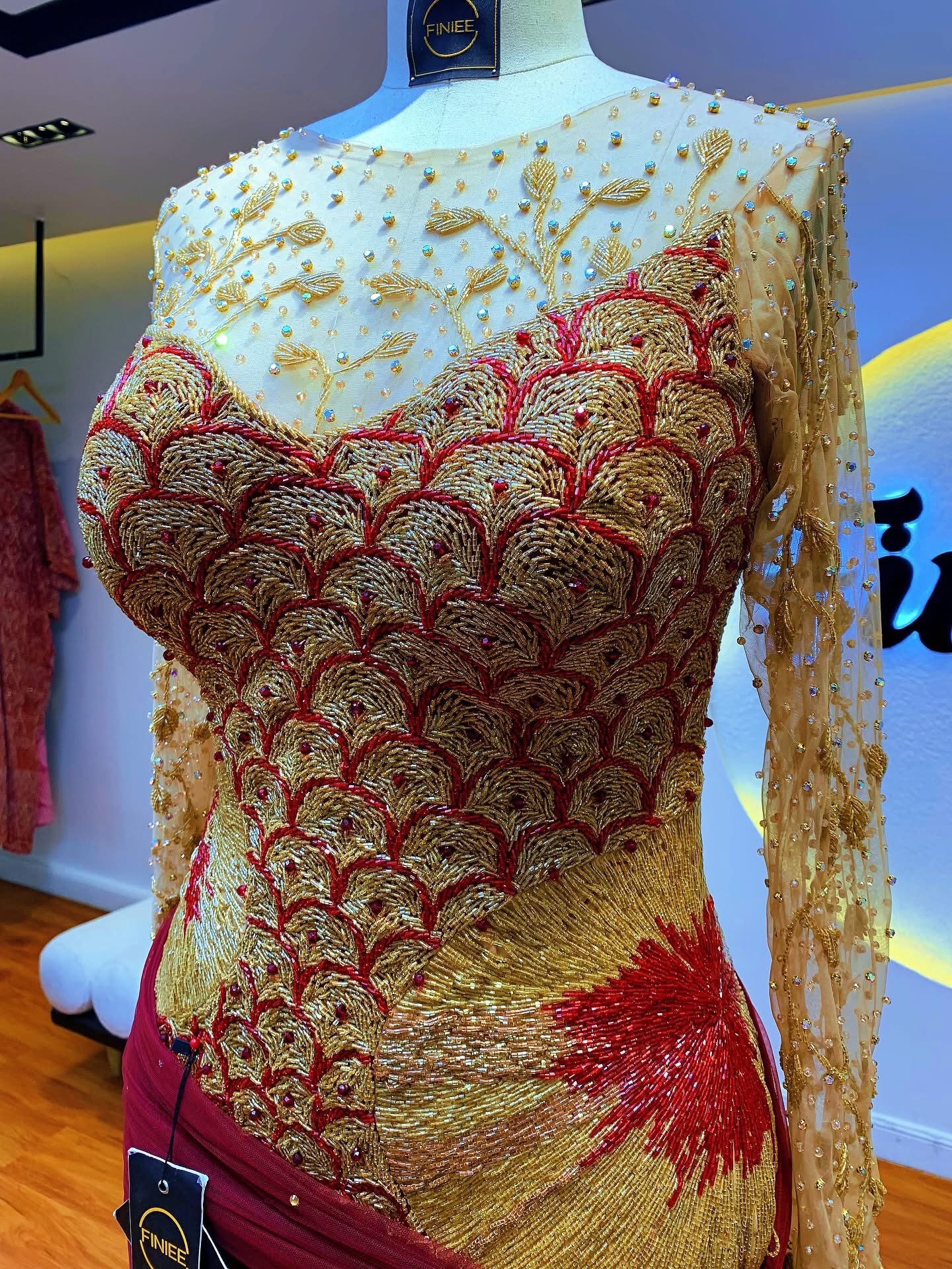 Gold and red scale-pattern beadwork on mannequin in the Finiee atelier
